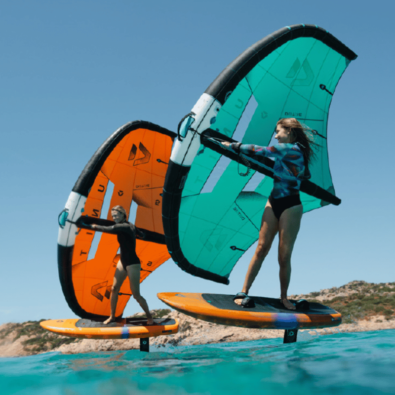 Two people riding wing foil boards holding wings